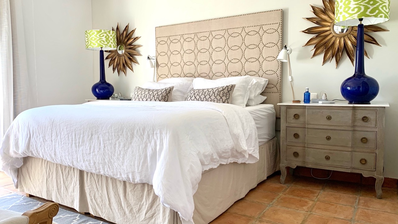 Bedroom with double bed, patterned headboard and bedside lamps