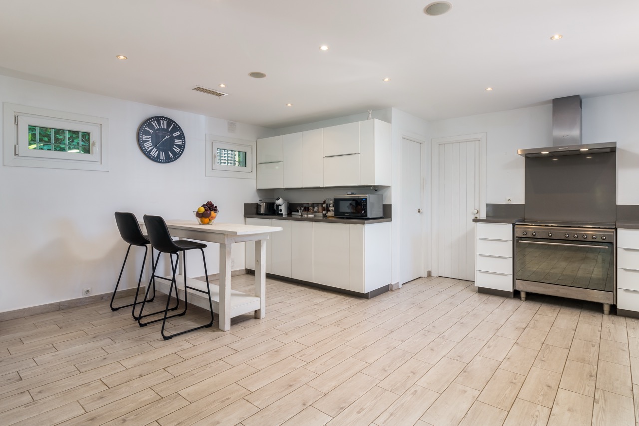 Cocina y comedor con escalera y acabados modernos en blanco