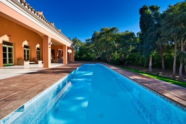 Swimming pool beside the villa with terrace and landscaped garden