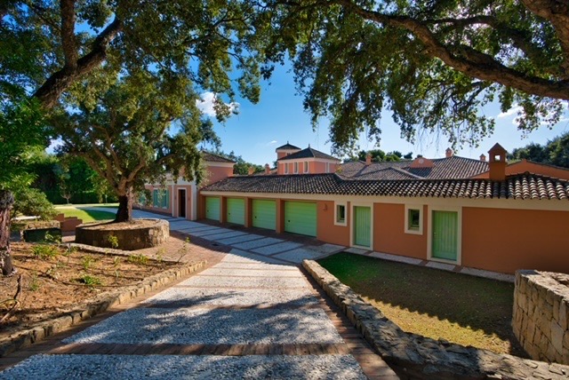 Villa exterior with garden, mature trees and terracotta façade
