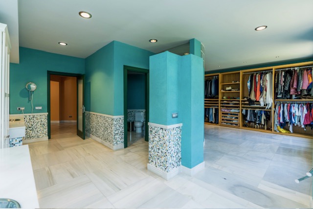 Dressing room with turquoise walls, wardrobes and central column