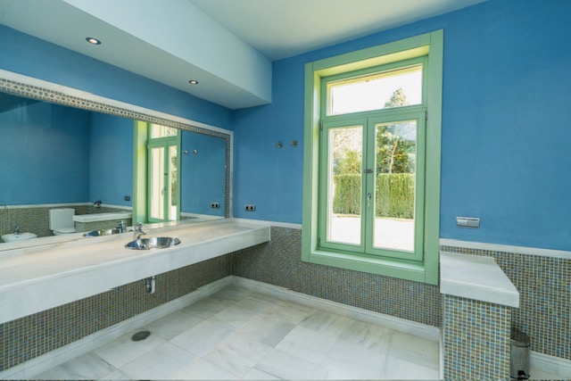 Bathroom with bathtub, vanity and blue tiled walls