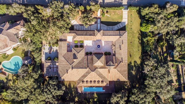 Aerial view of frontline golf villa with swimming pool, gardens and surrounding greenery in Sotogrande Alto