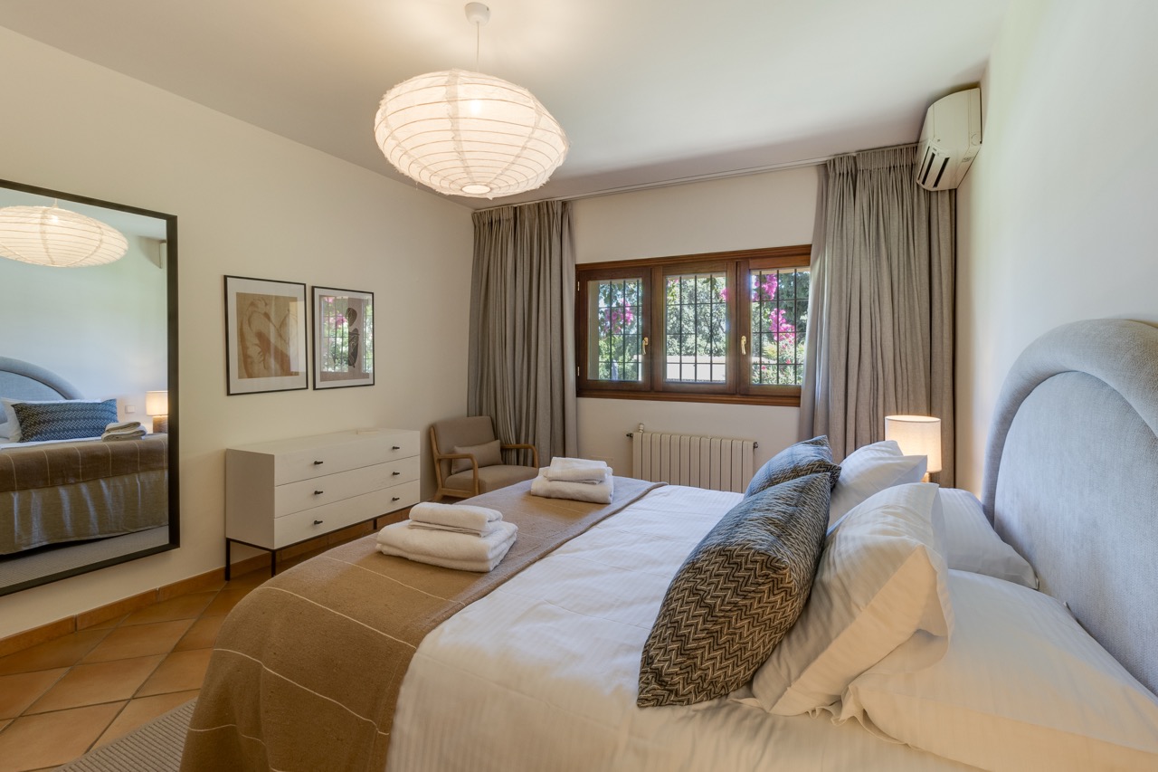 Dormitorio con cama doble, tocador y luz natural