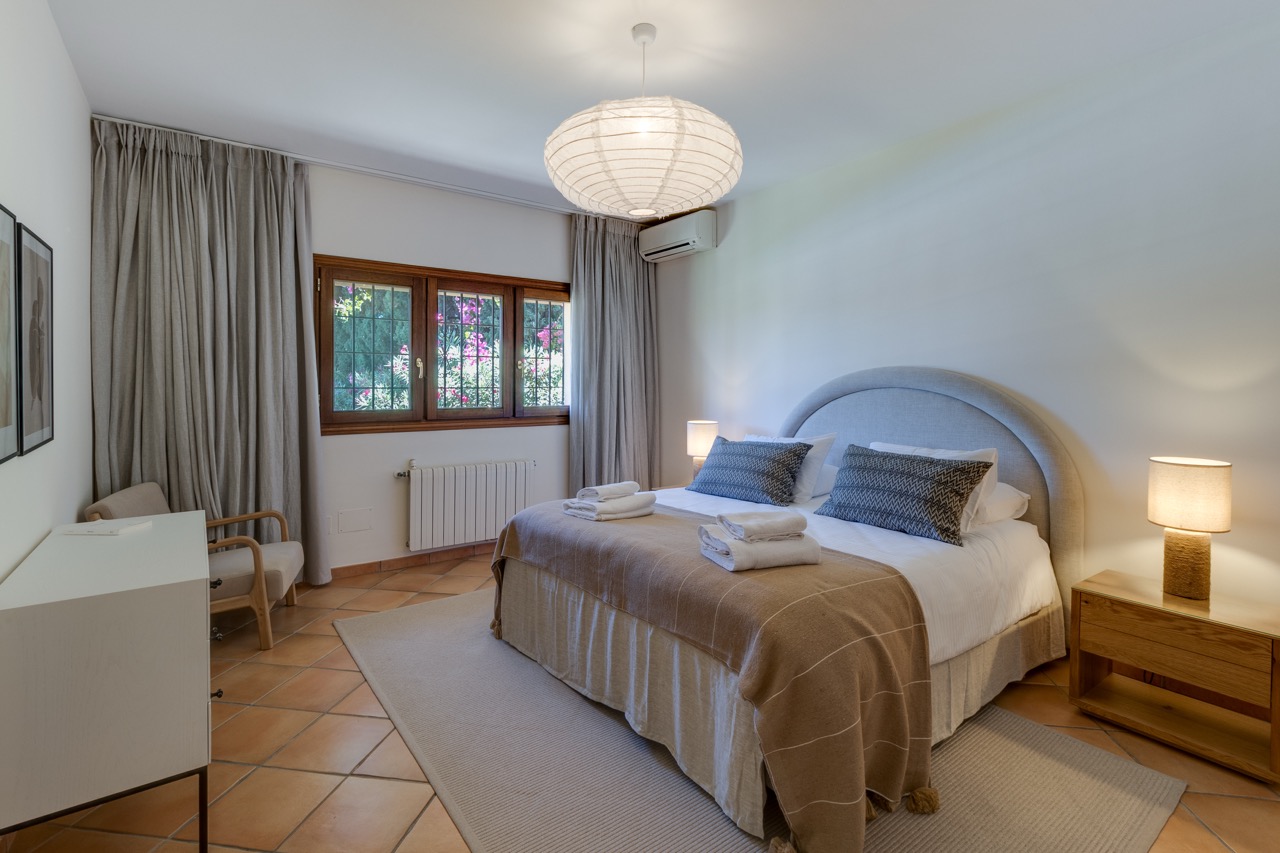 Dormitorio con cama doble, lámparas de noche y suelo de madera