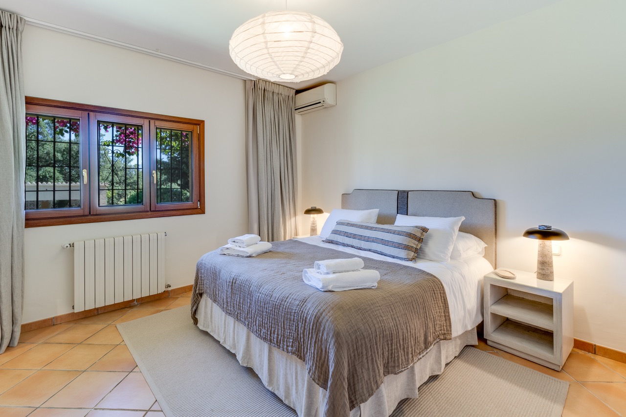 Dormitorio con cama doble, suelo de madera y luz natural