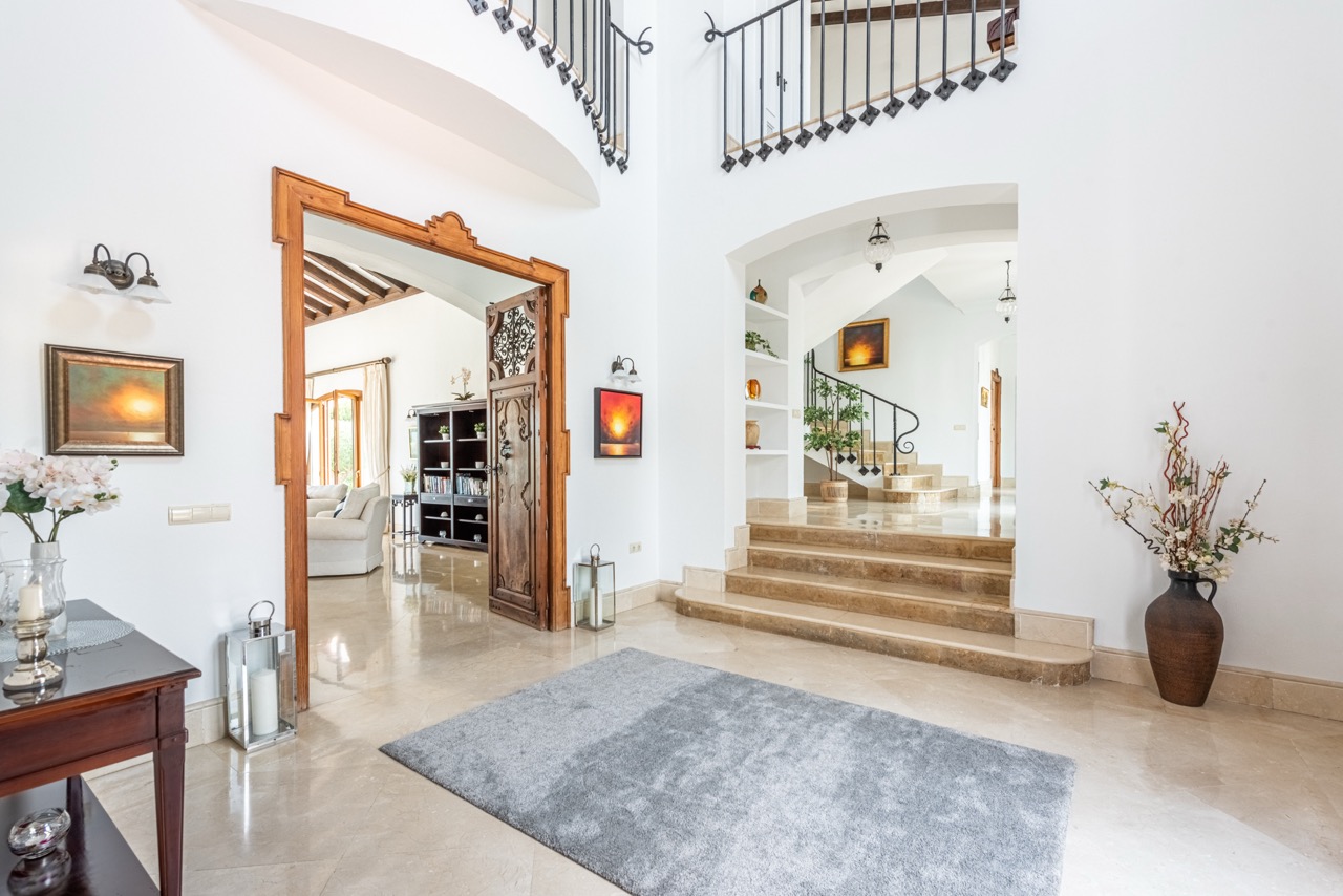 Entrance hall with staircase, arched doorway and bright interior finishes
