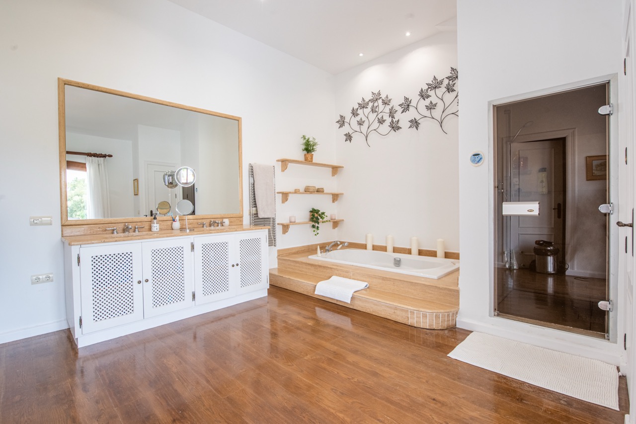 Bathroom with double vanity, bathtub and tiled finishes