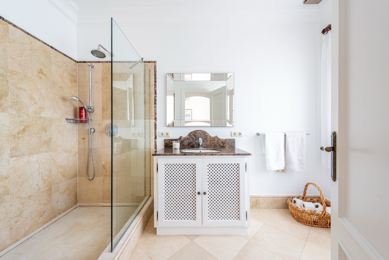 Bathroom with walk-in shower, vanity unit and tiled walls