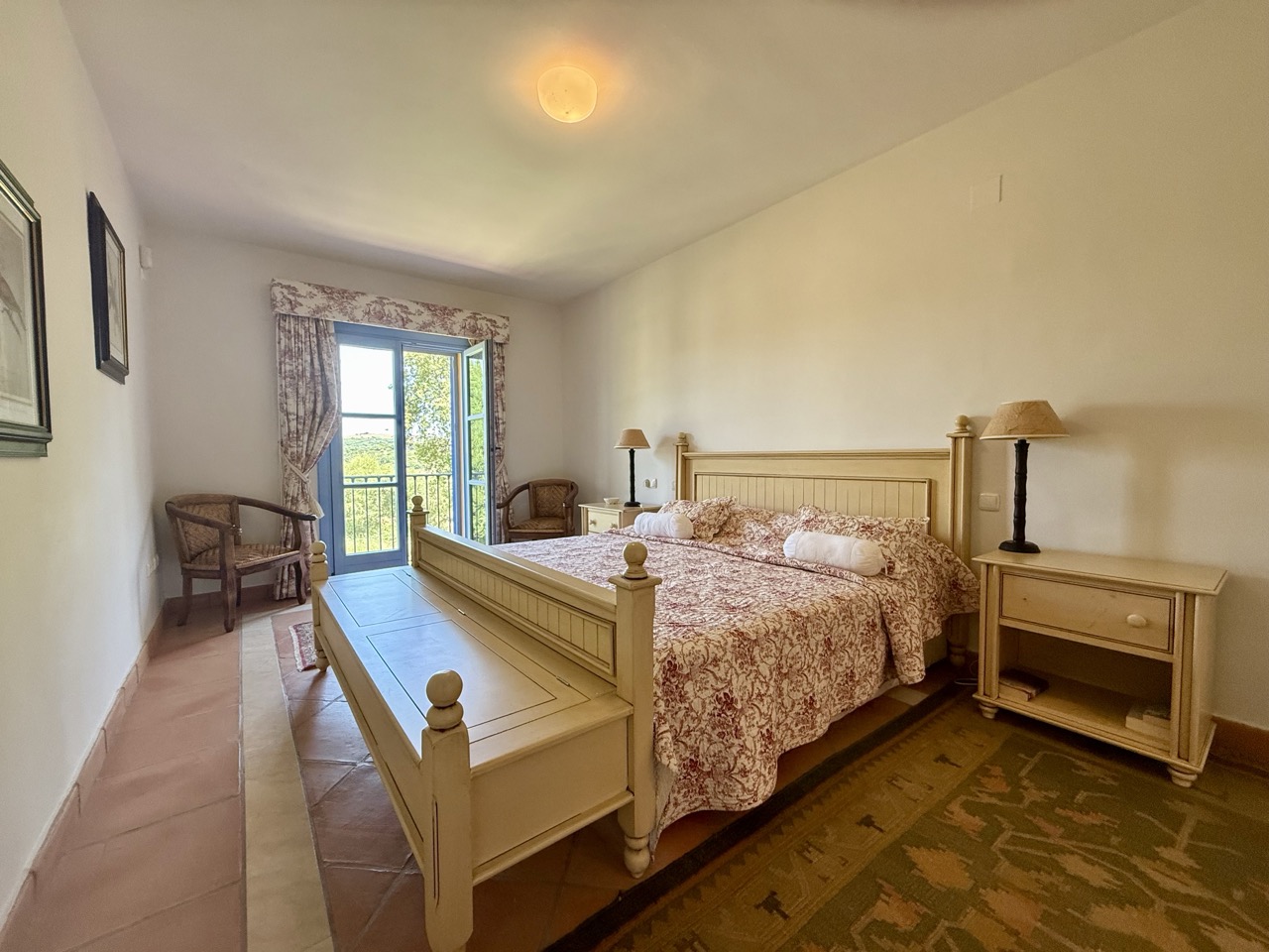 Dormitorio con dos camas individuales, suelo de madera y puertas al jardín