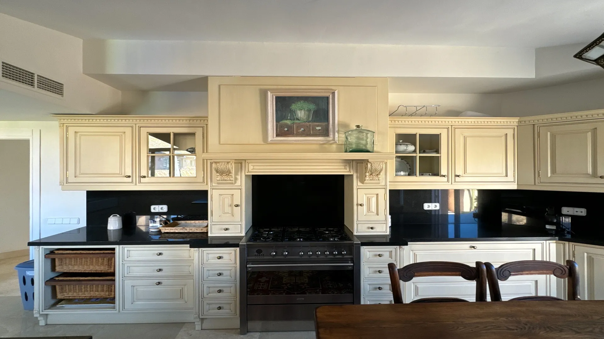 Cocina con barra de desayuno, muebles blancos y electrodomésticos integrados