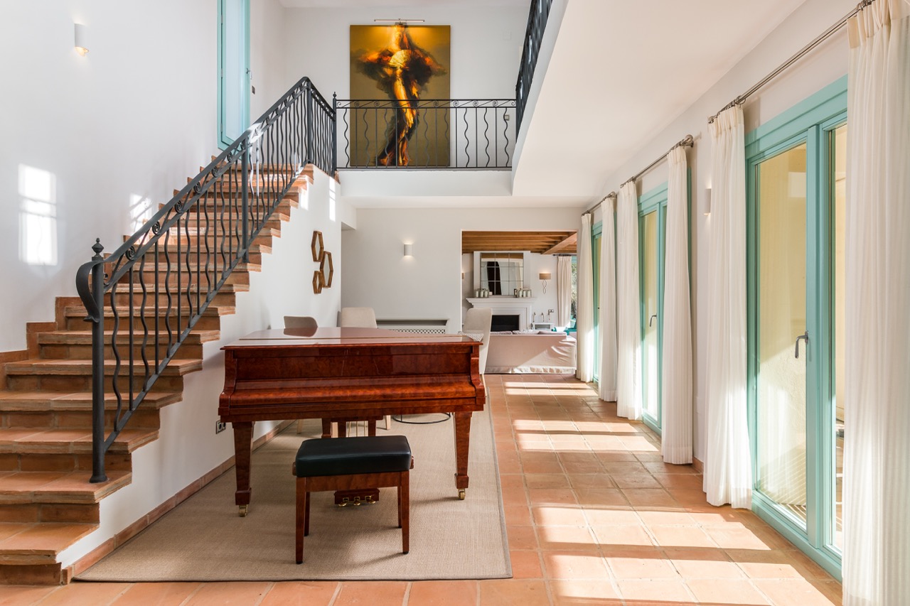 Recibidor con escalera, piano y amplias puertas de cristal