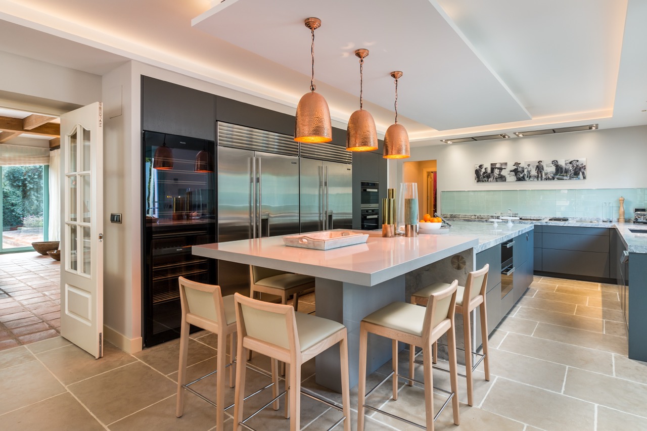 Cocina moderna con isla, mesa de comedor y lámparas colgantes