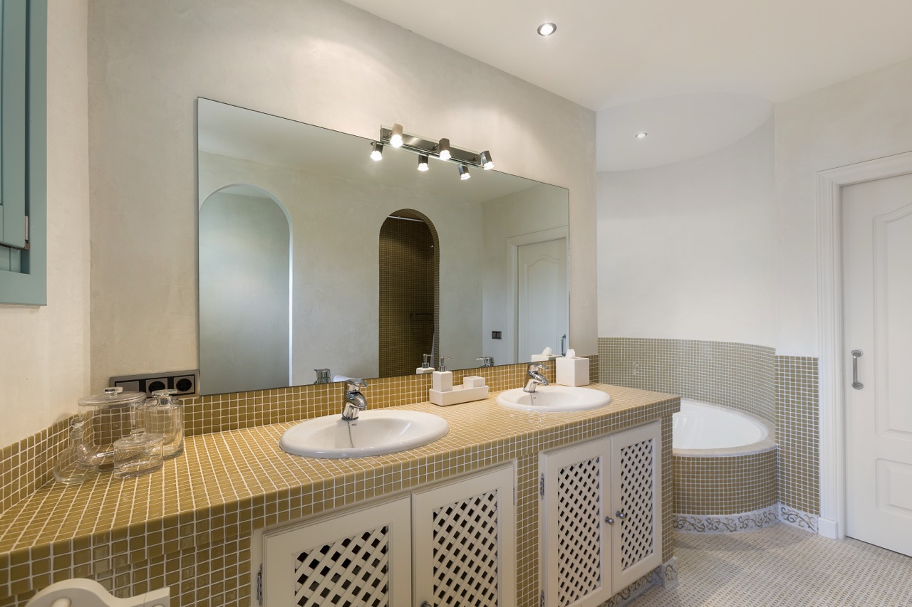 Baño con mueble de lavabo, bañera y alicatado en tonos neutros