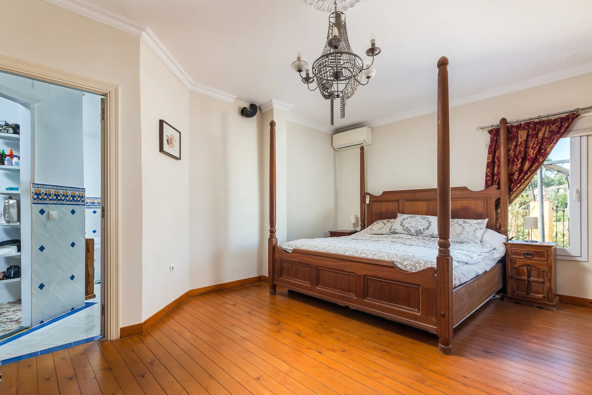 Bedroom with four-poster bed, wooden flooring and fireplace