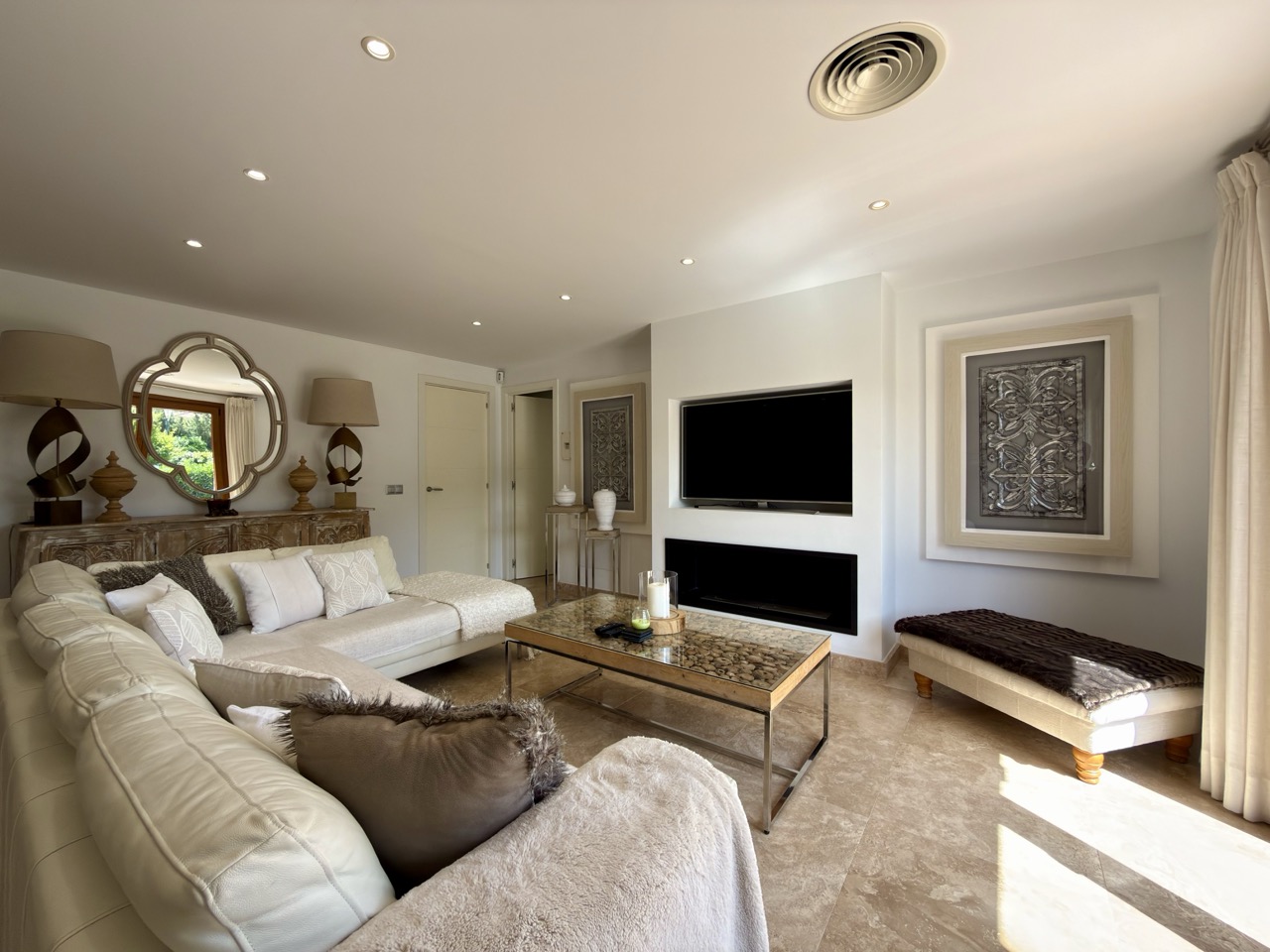 Living room with sofa seating, TV wall and neutral finishes