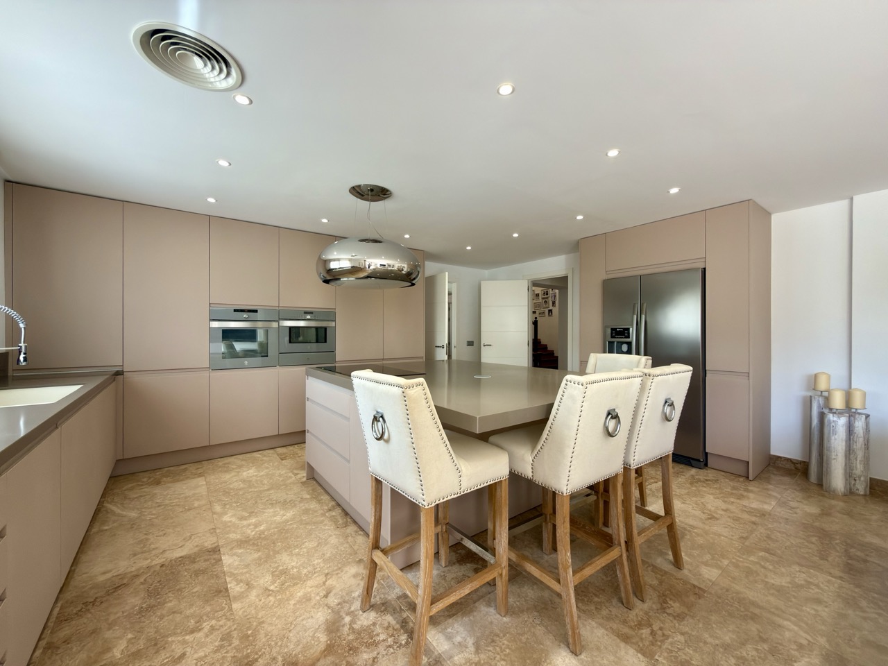 Cocina y comedor con mesa de madera, acabados neutros y luz natural
