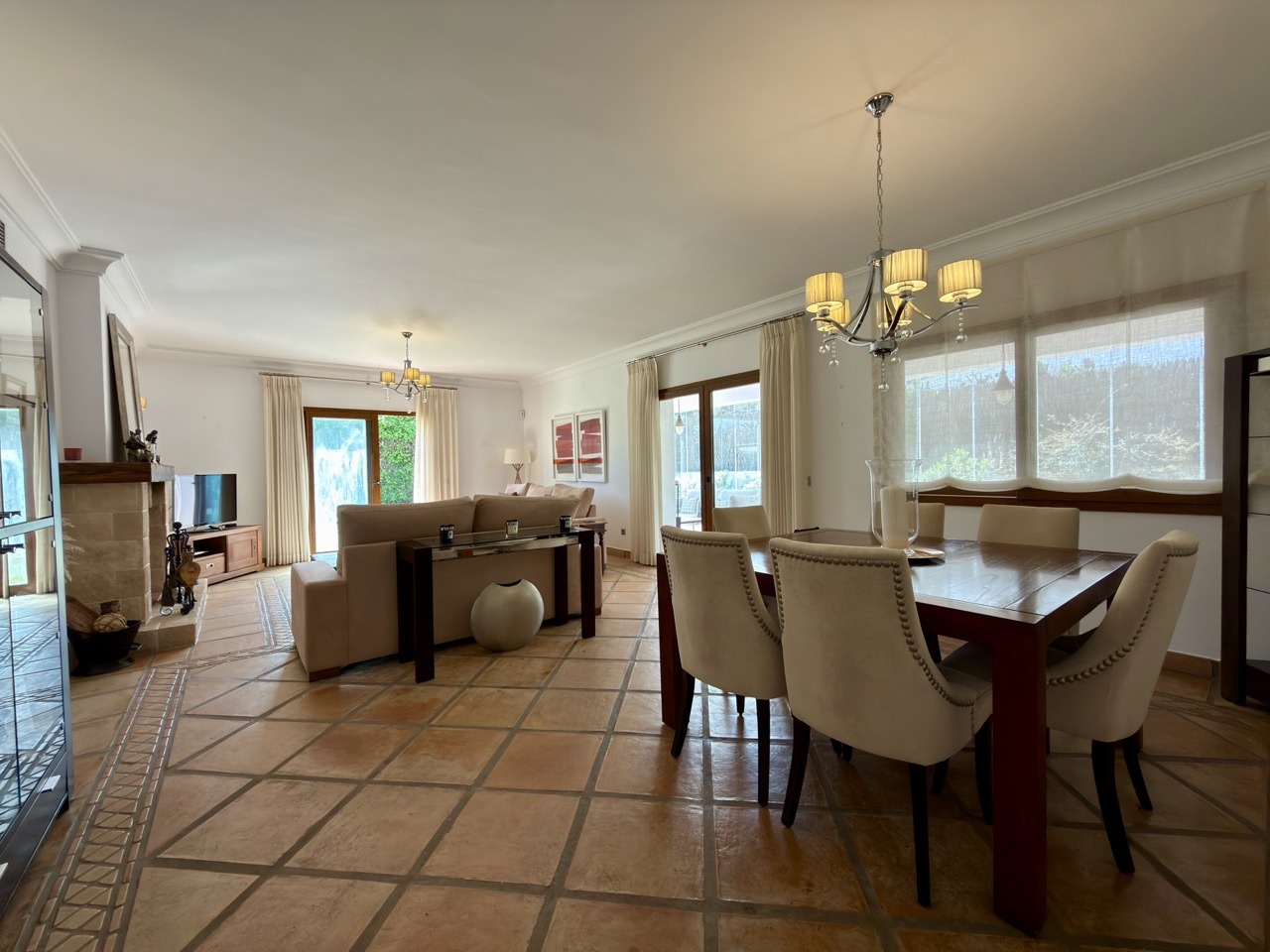 Dining and living area with terracotta flooring and garden-facing windows