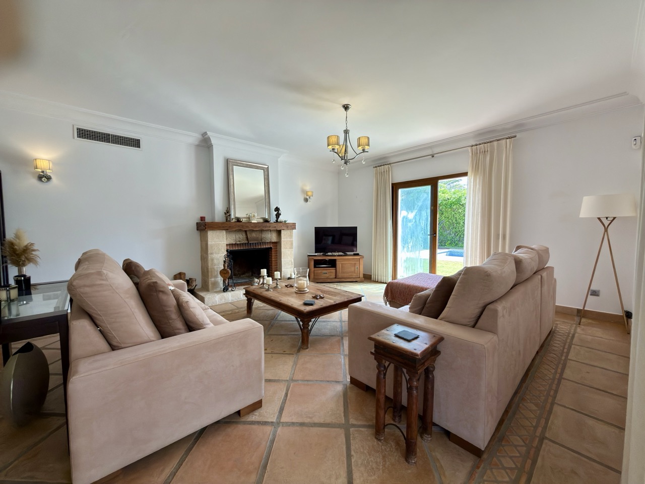 Living room with sofa seating, fireplace and garden access