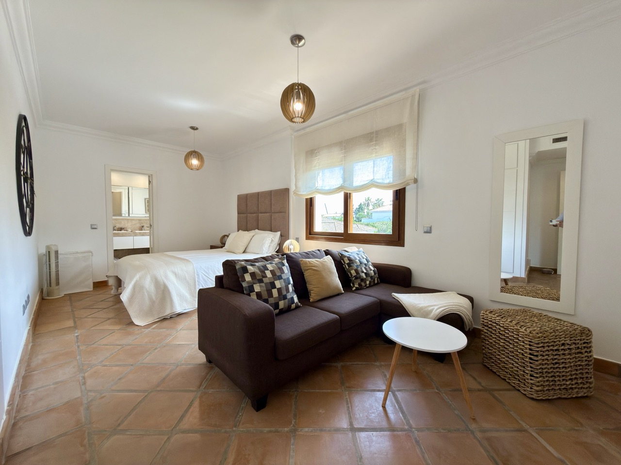 Bright bedroom with sofa seating and window overlooking the garden