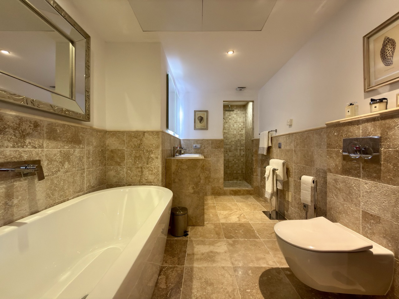 Bathroom with bathtub, bidet and marble-style finishes