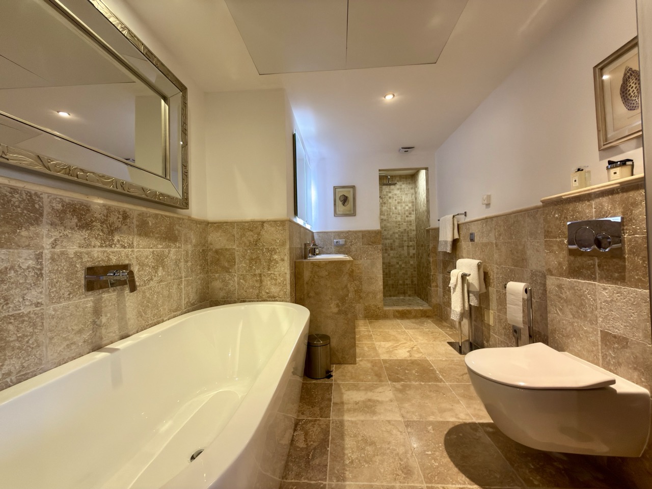 Bathroom with freestanding bathtub and marble walls