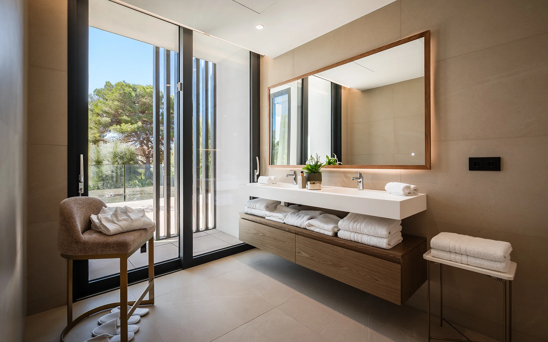 Baño con doble lavabo, espejo grande y ventanal de suelo a techo