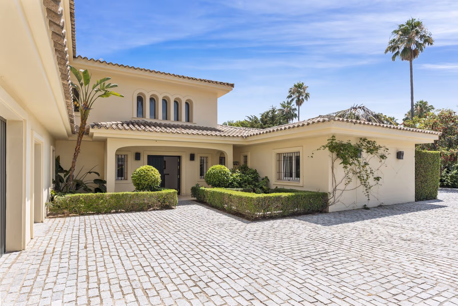 Exterior de villa andaluza moderna con patio de entrada y fachada blanca