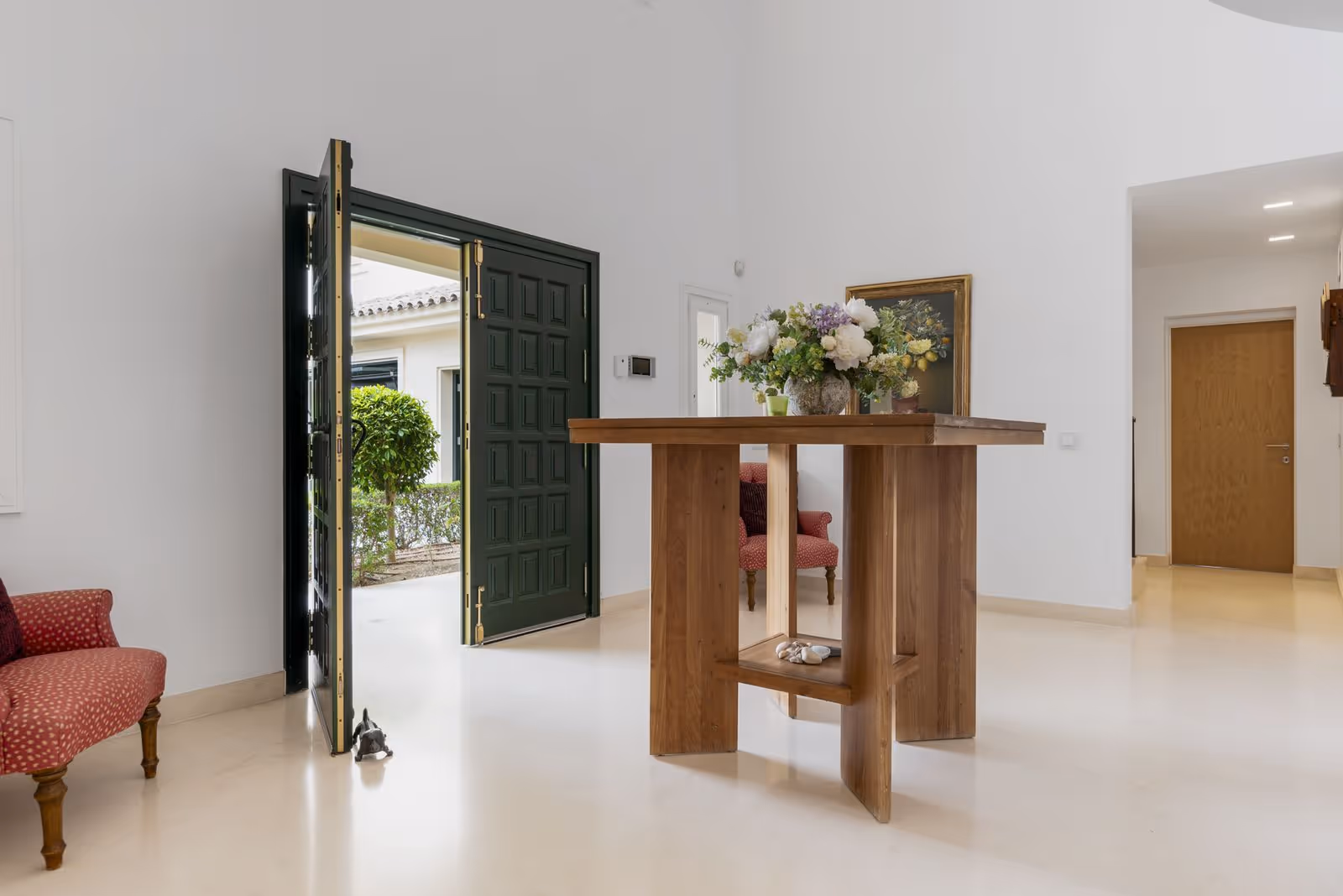 Entrance hall with open front door, console table and bright interior finishes