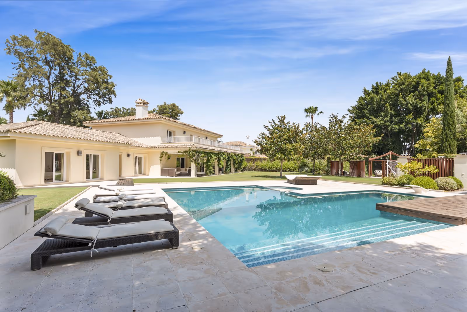 Swimming pool with sun loungers, terrace and garden views