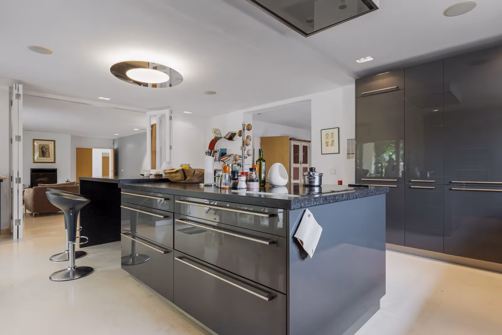 Cocina moderna con isla, muebles grises y barra de desayuno con taburetes