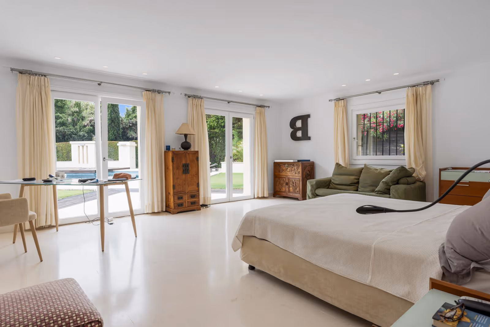 Bedroom with double bed, garden-facing doors and neutral decor
