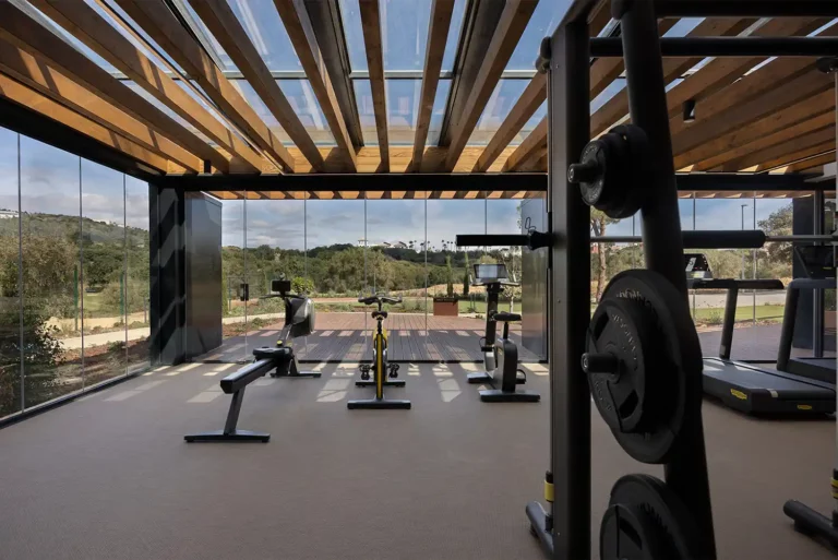 Community gym with weights and fitness equipment overlooking the gardens