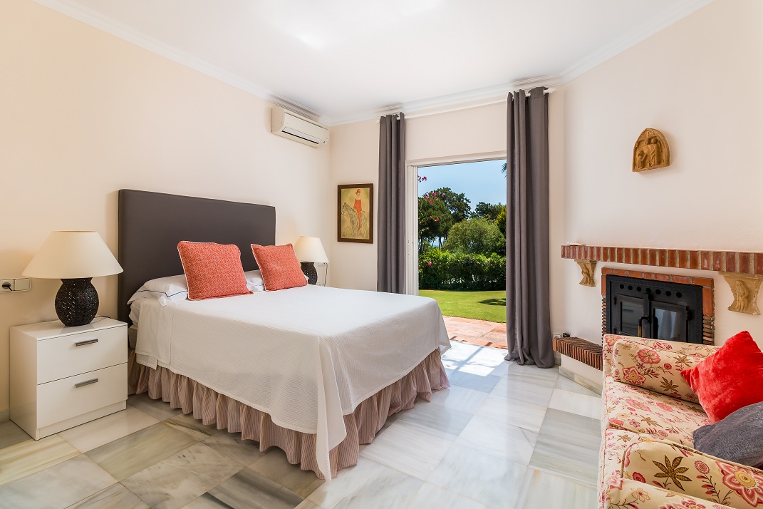 Bedroom with double bed, fireplace and garden-facing doors