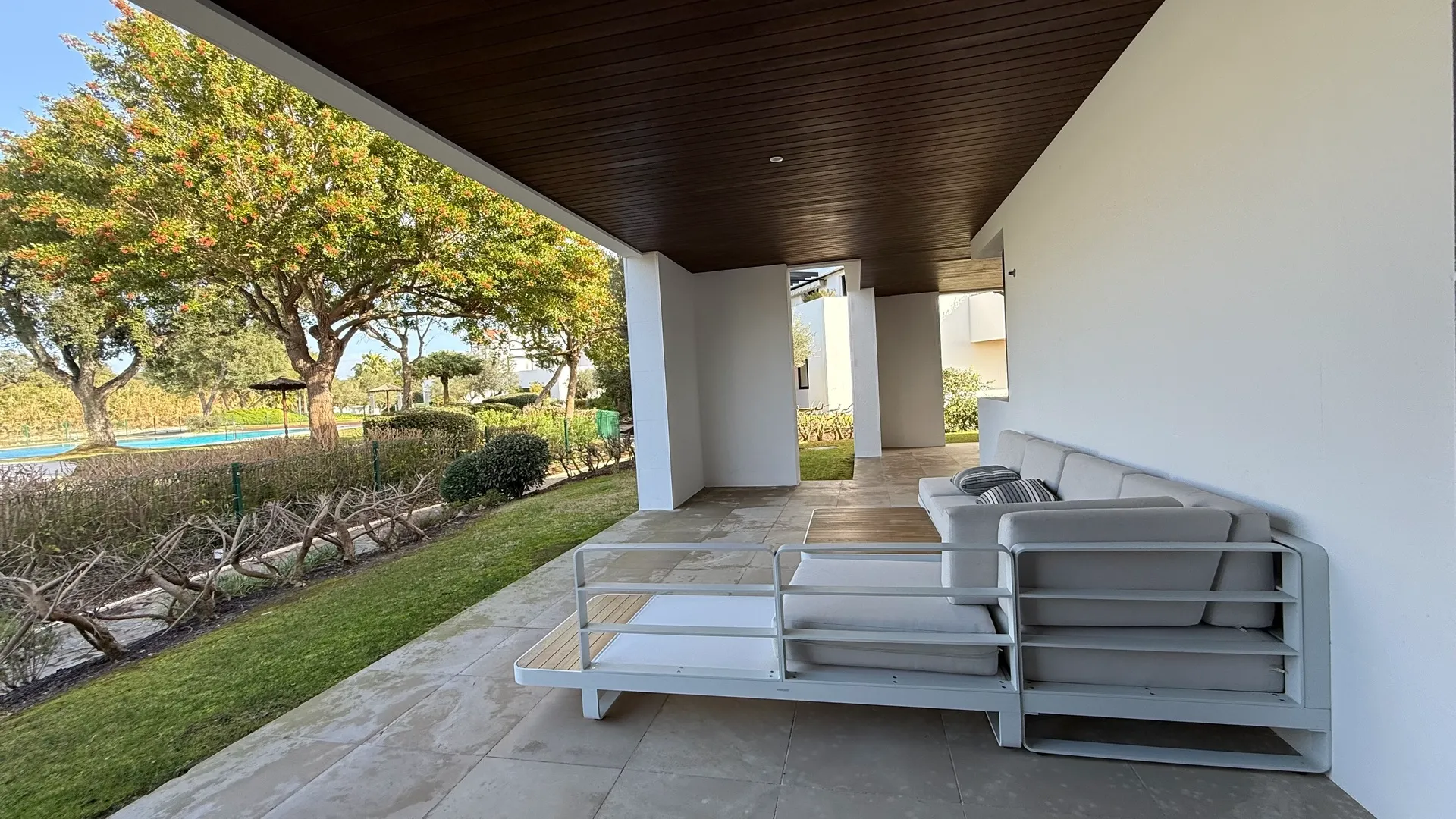 Terraza cubierta con sofás exteriores y vistas al jardín