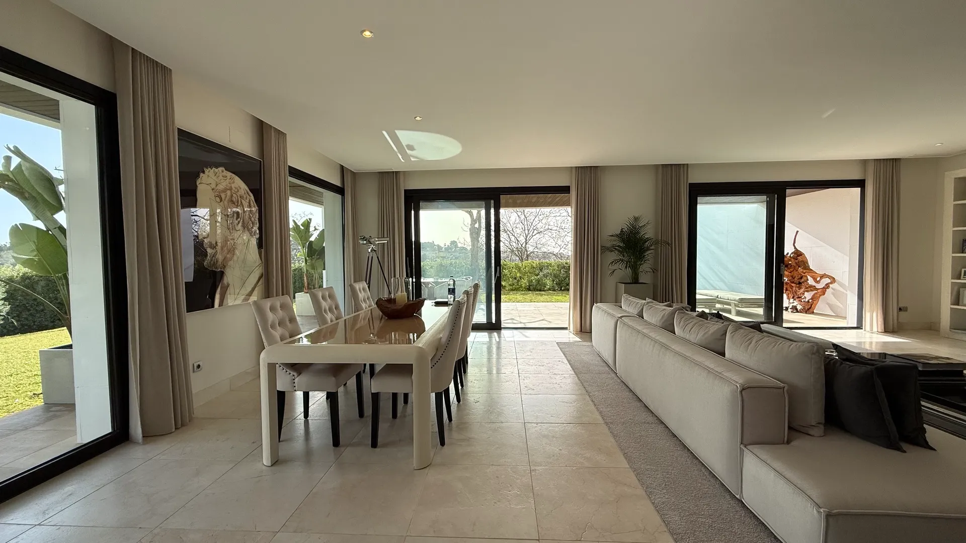 Salón comedor diáfano con amplias puertas de cristal a la terraza