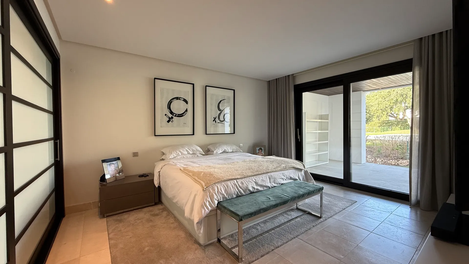Dormitorio con cama doble, amplias puertas correderas y acceso a la terraza