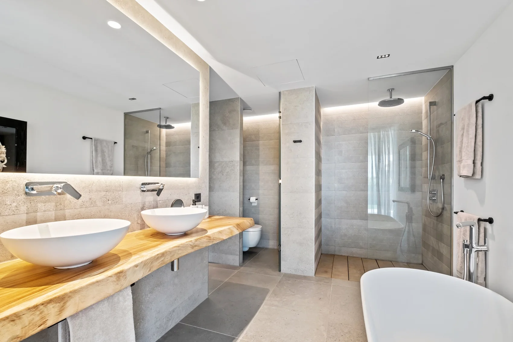 Baño en suite principal con doble lavabo, bañera exenta y ducha de lluvia a ras de suelo