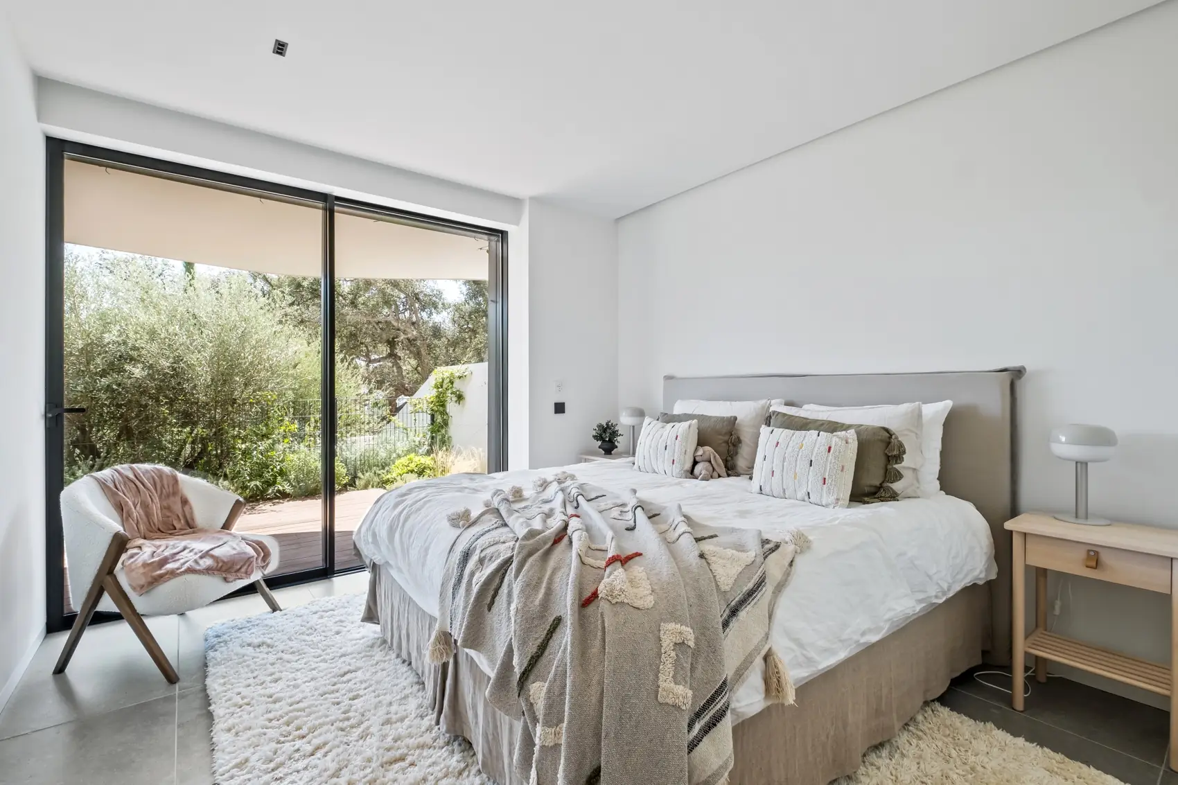 Segundo dormitorio con cama doble y puertas correderas a la terraza de madera del jardín