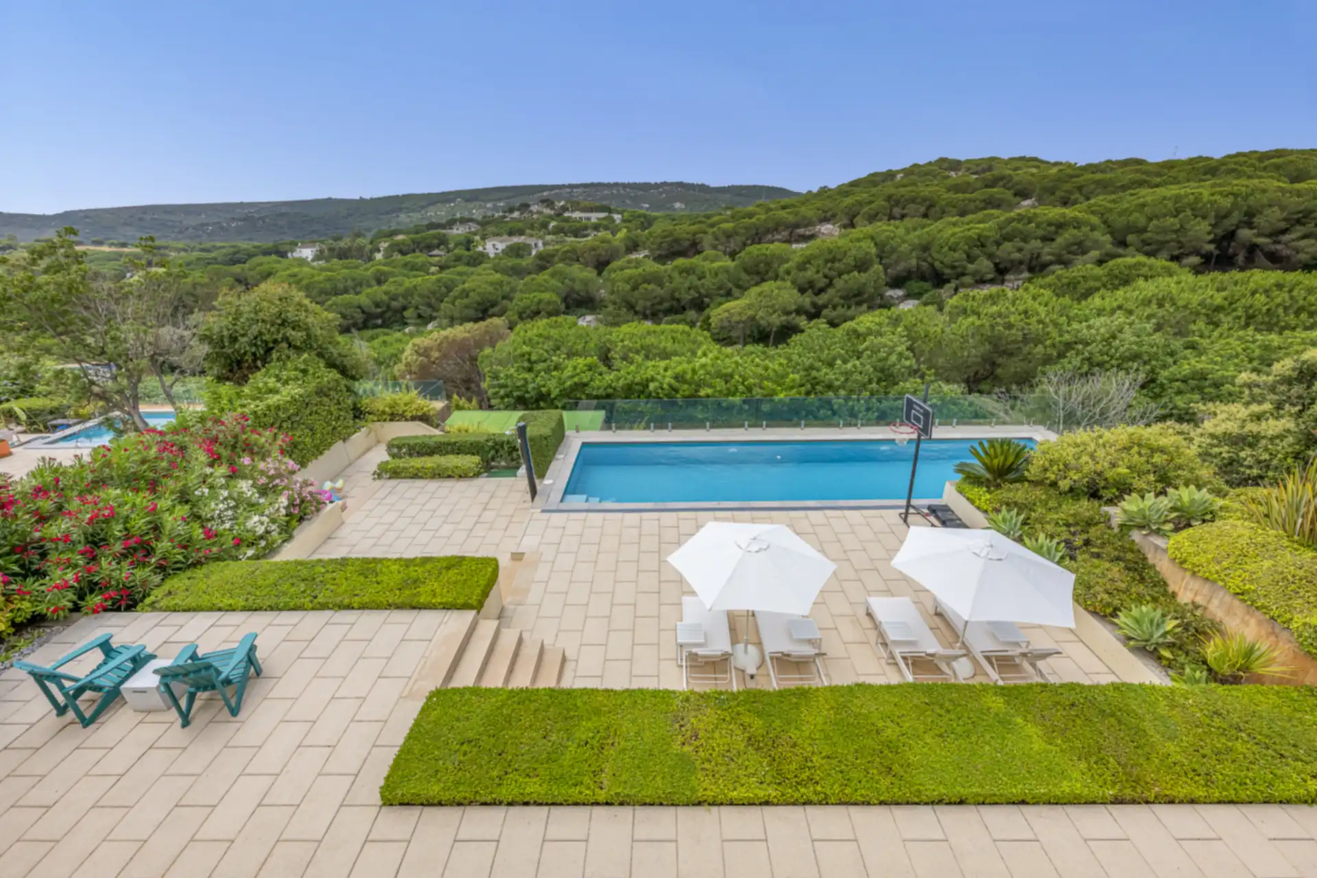 Swimming pool and landscaped terraces looking out over pine-covered hills