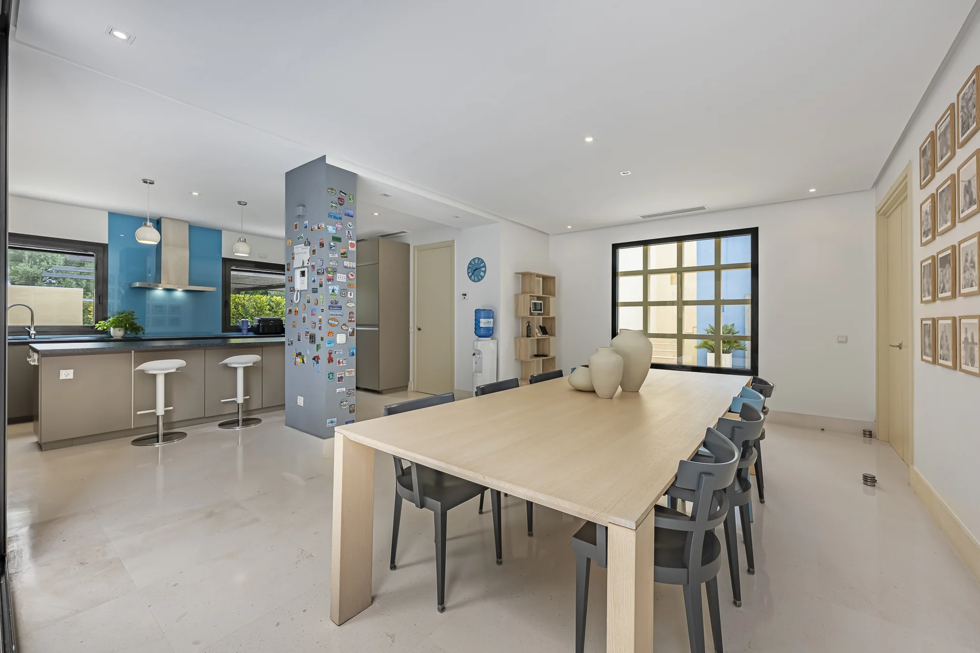 Kitchen with breakfast bar opening onto a dining area with a long wooden table