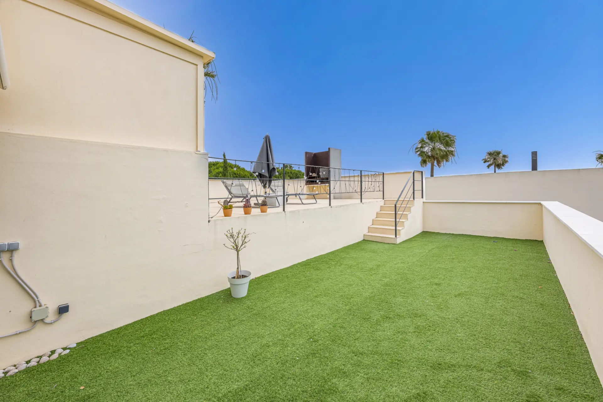 Walled lawn with steps up to the barbecue terrace