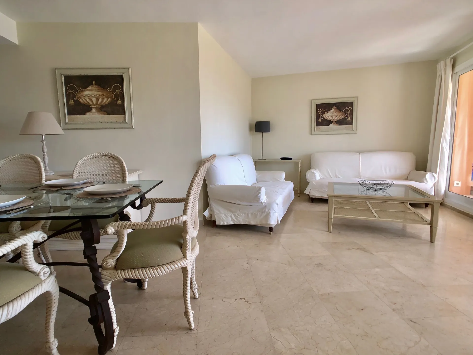 Salón comedor con mesa de cristal, sillones y sofás