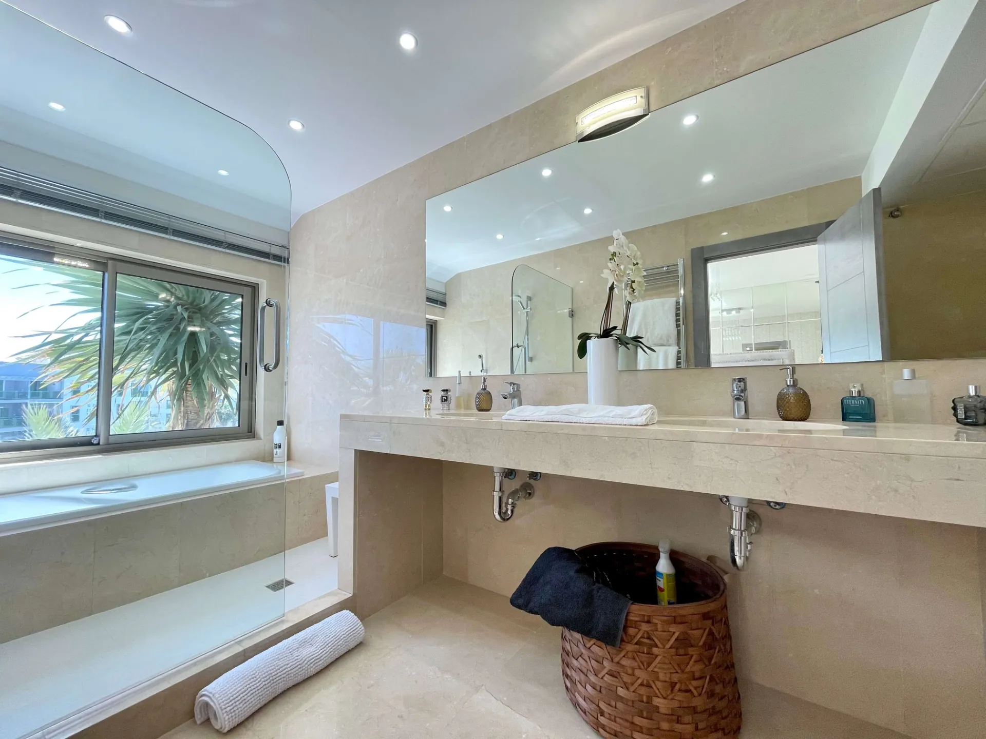 Baño con bañera, doble lavabo y ventana grande