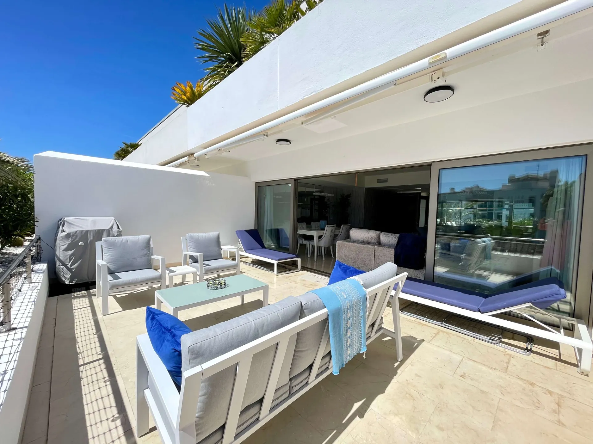Terraza del ático con comedor exterior, zona chill out y puertas de cristal