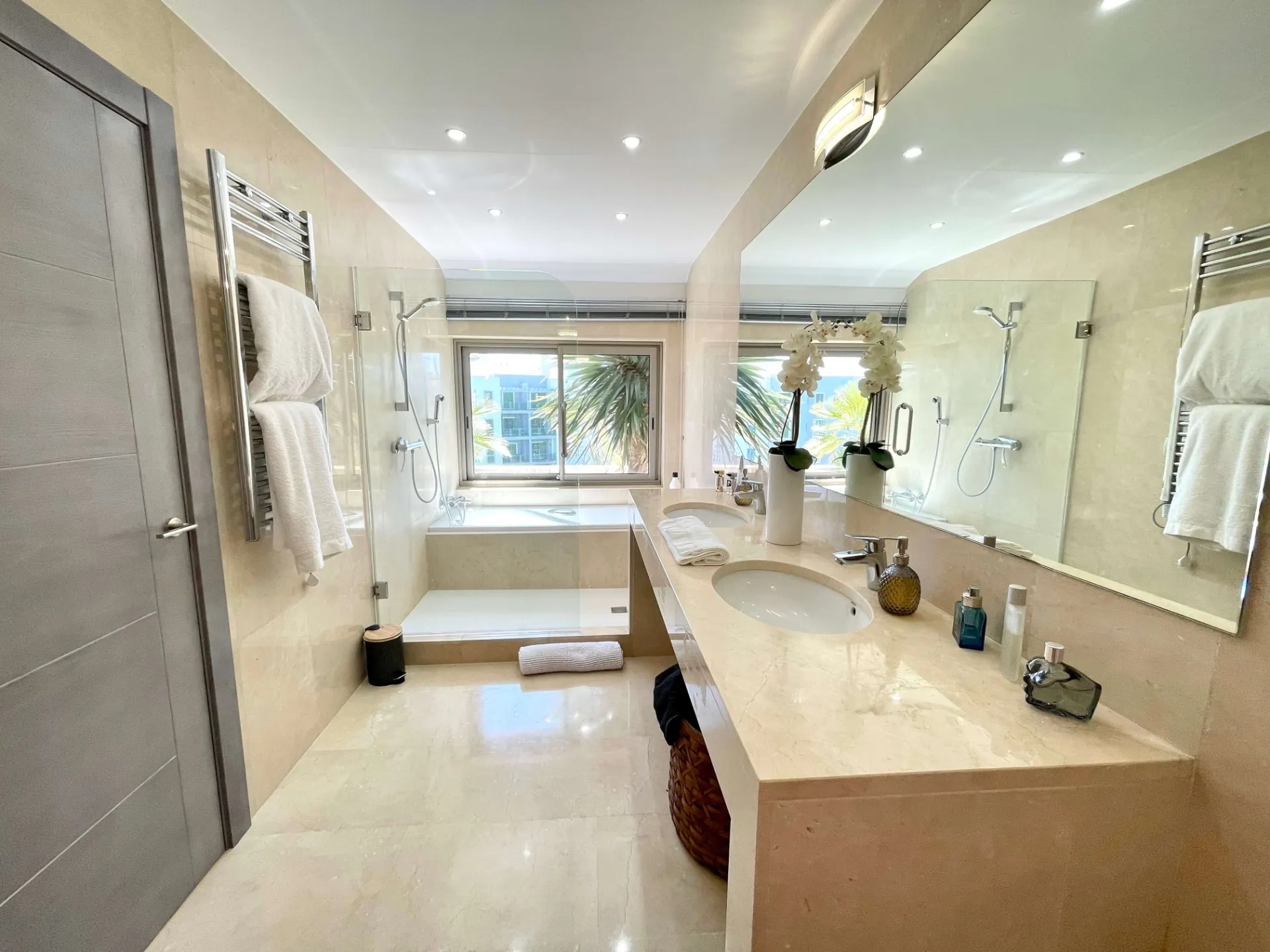 Baño con doble lavabo, bañera y pared de espejo
