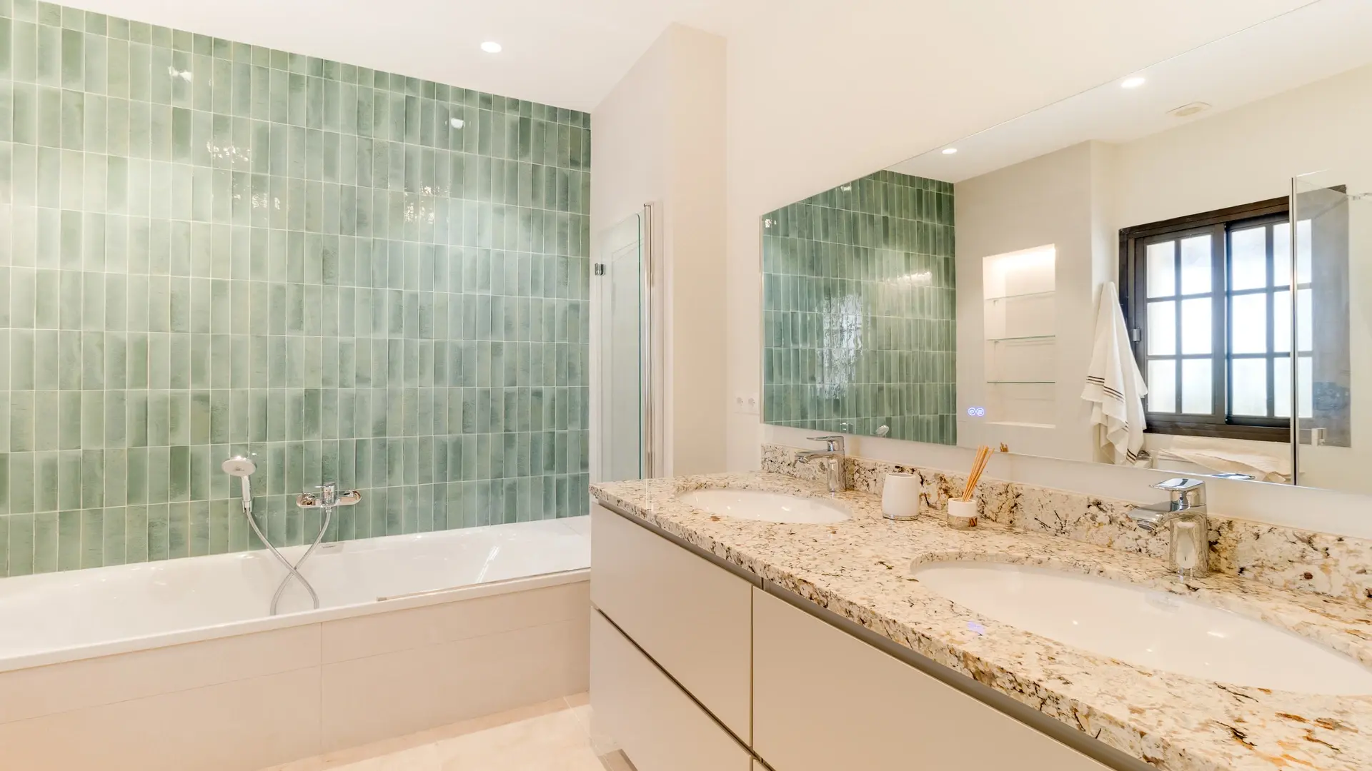 Bathroom with green tiled feature wall, double vanity and window