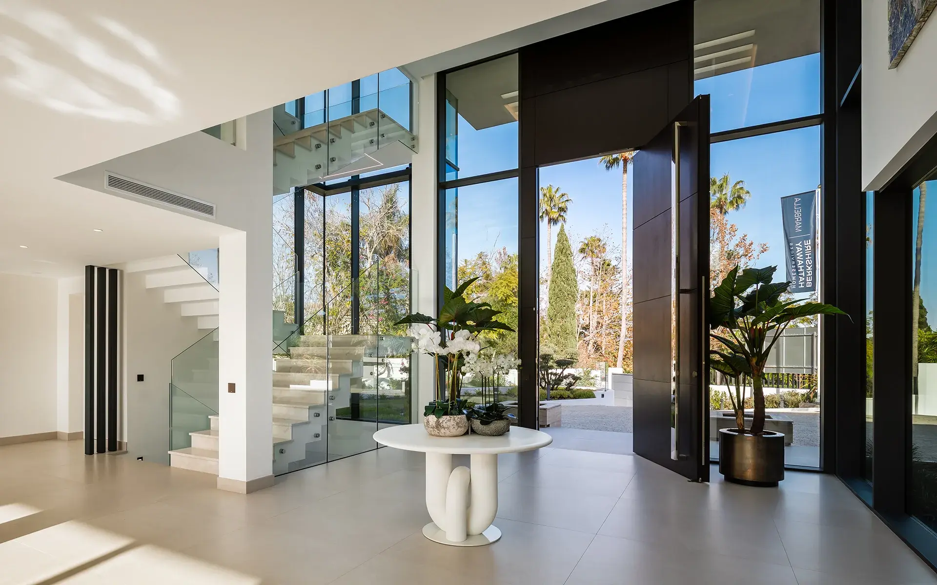 Recibidor contemporáneo con puertas de cristal de suelo a techo y vistas al jardín