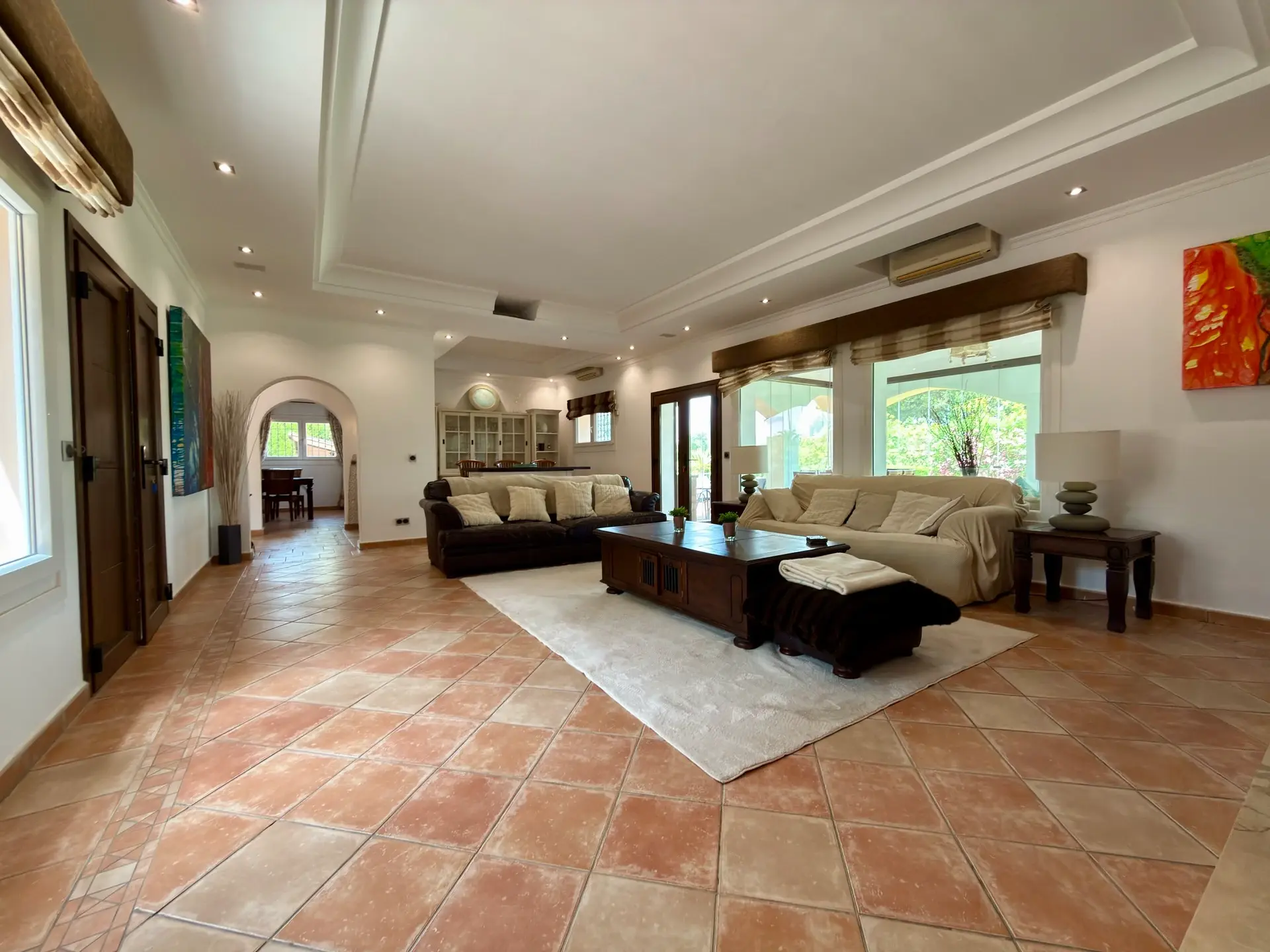 Open-plan living and dining area with terracotta flooring and garden views