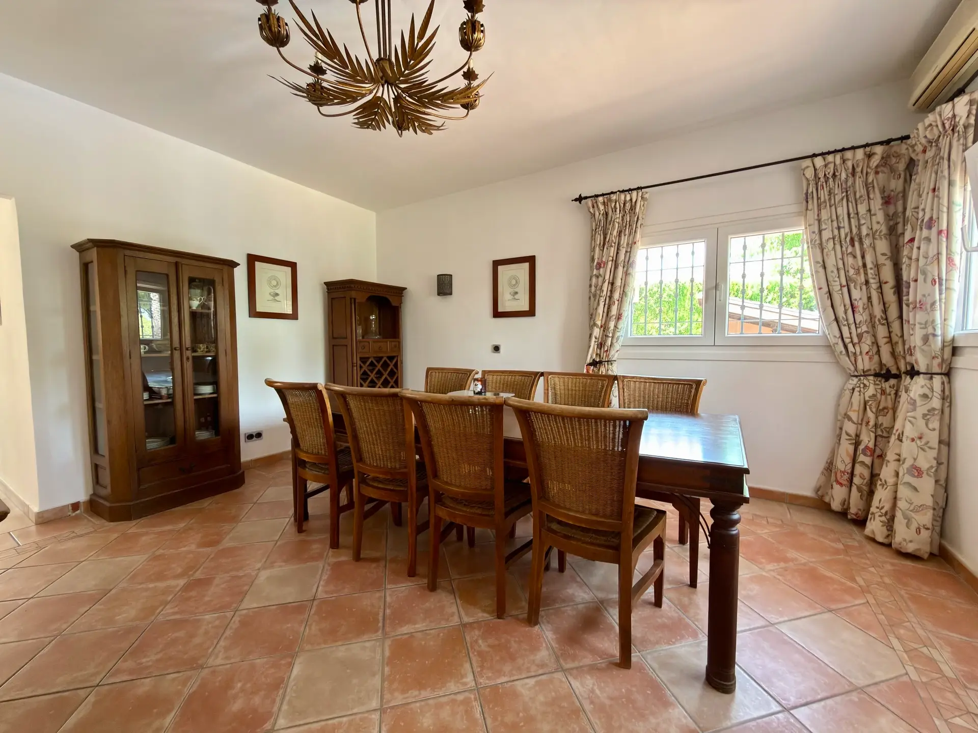 Dining room with wooden table, chandelier and terracotta flooring